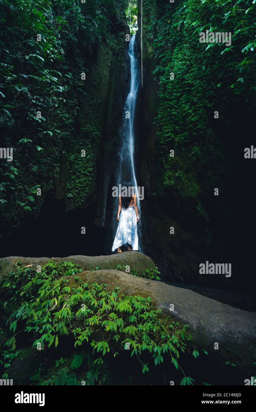 A woman meditates in nature. Meditation at the waterfall. Young woman ...