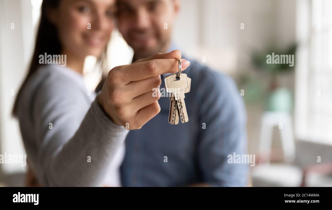 Close up happy young woman hugging man, holding keys Stock Photo