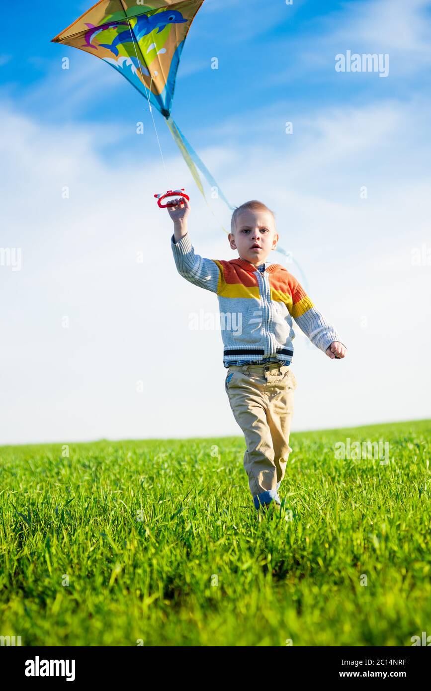 Girl Kid Running Flying Kite Toy Holding Rope On Green Meadow