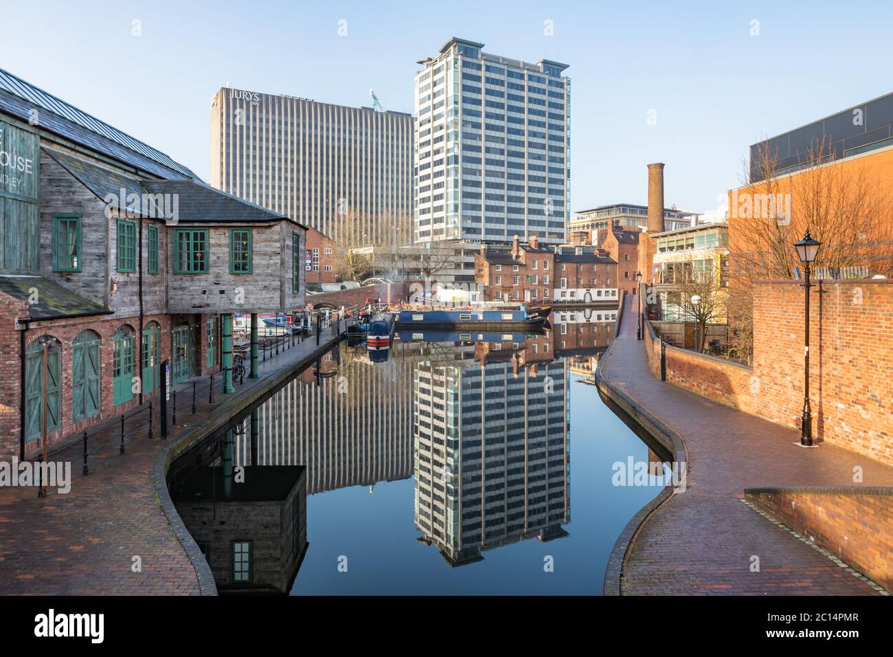 Birmingham, UK - 24/02/19: Gas Street canal basin with moored narrowboats. Old canal buildings and modern tower blocks are reflected in the water. Stock Photo