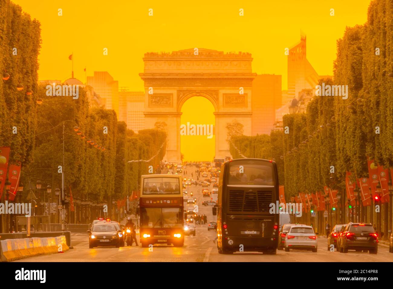 France. Dense traffic on the Champs Elysees in Paris. Triumphal Arch and golden sunset Stock Photo