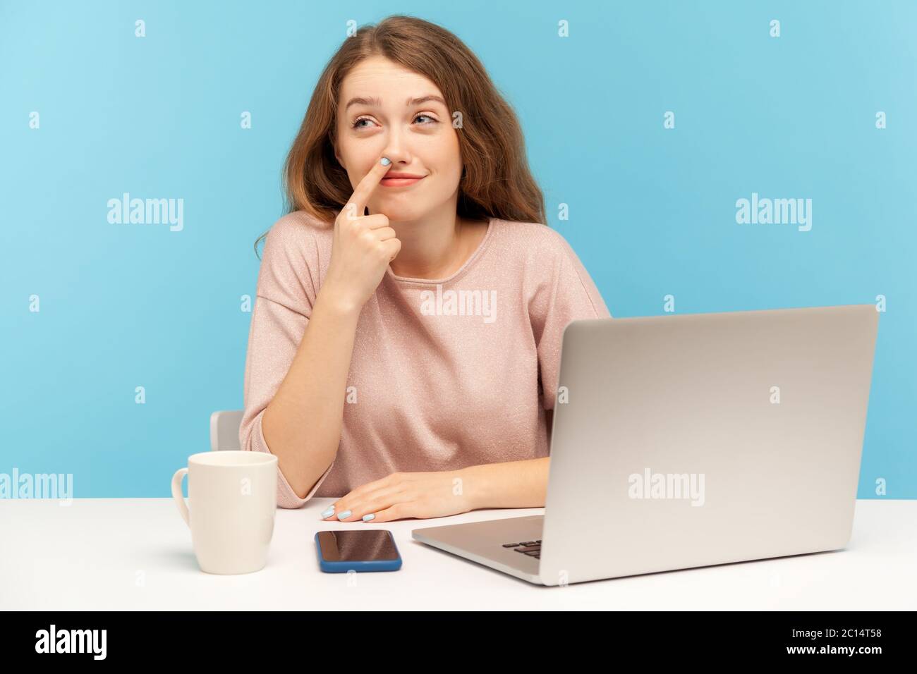 Lazy inefficient woman employee picking nose and looking away with dreamy careless comical expression, having break at workplace, indifferent to her j Stock Photo