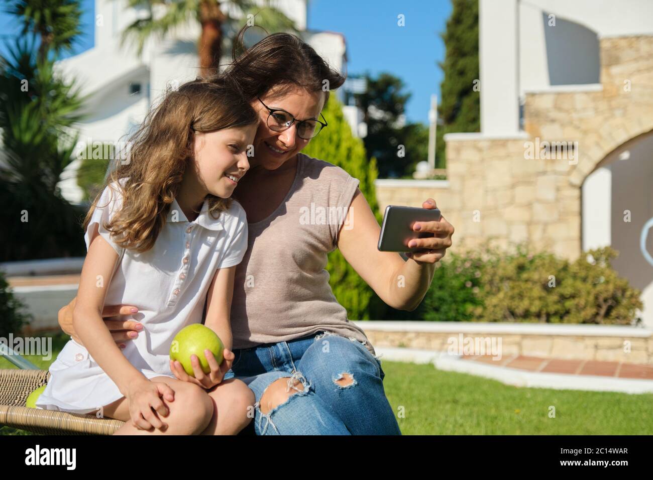 Mom and daughter kid using smartphone for video call Stock Photo - Alamy