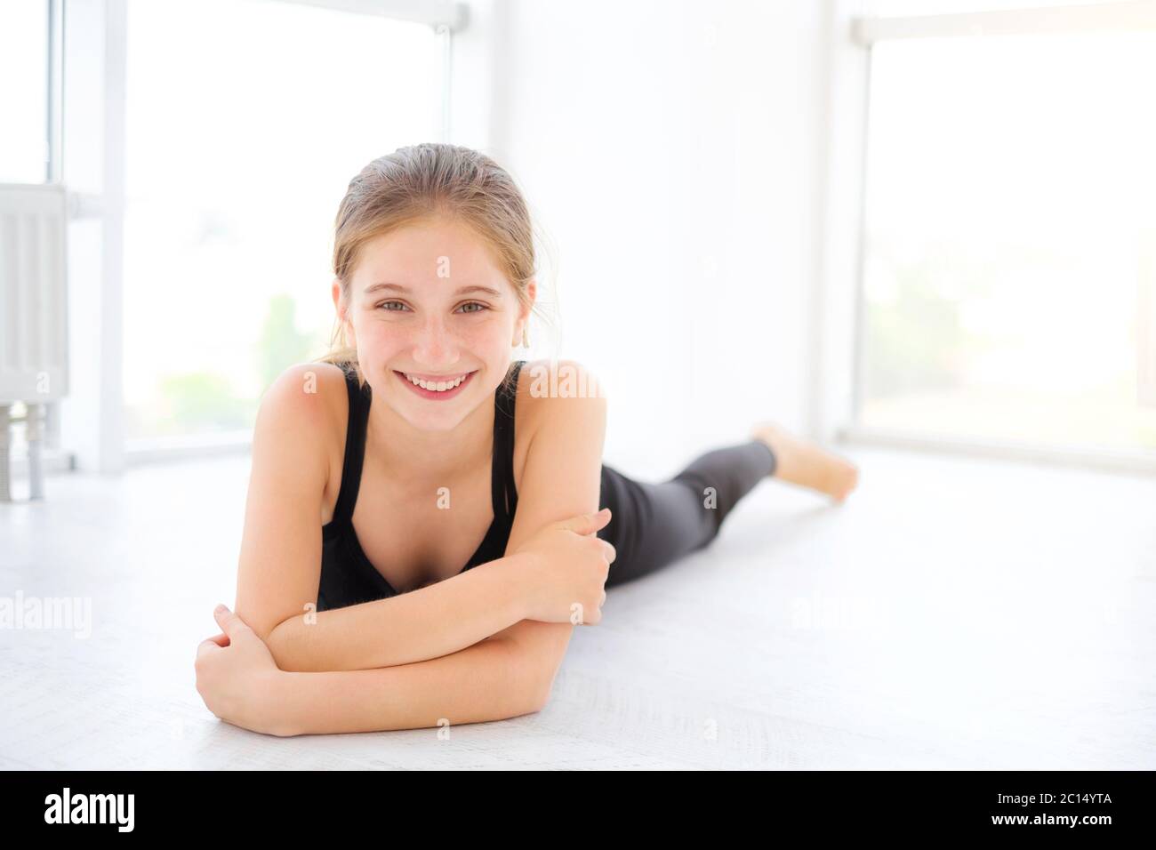 Cute teenager girl lying on a floor in light room Stock Photo - Alamy