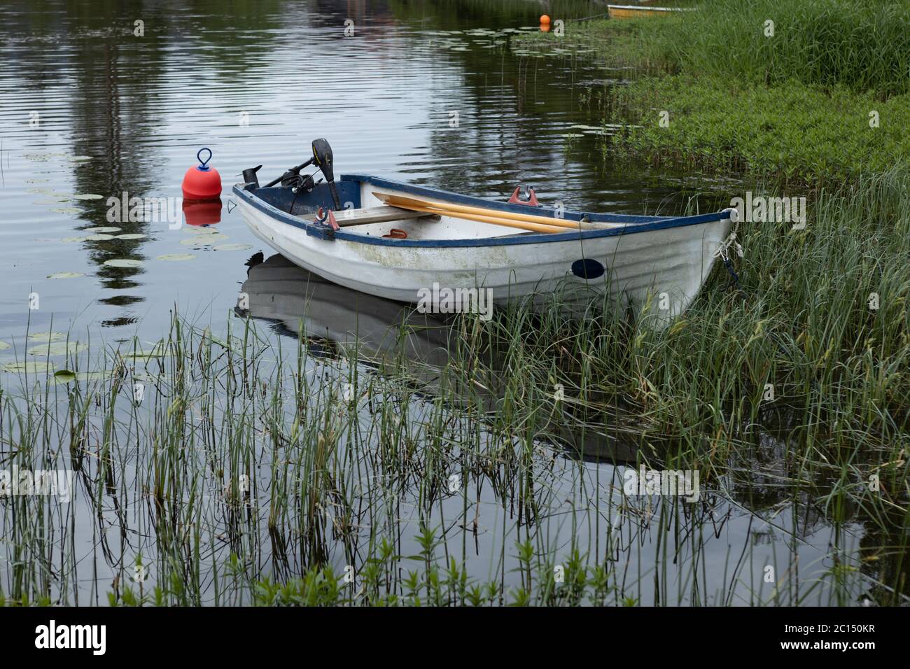 Plastic row boat with electric engine on a lake Stock Photo - Alamy