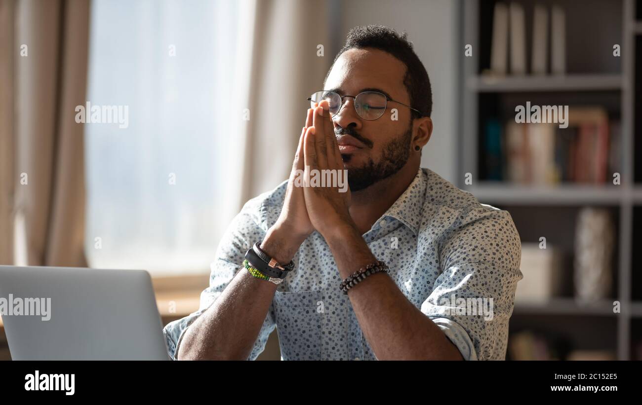 African closed eyes put palms together thinking search problem solution Stock Photo