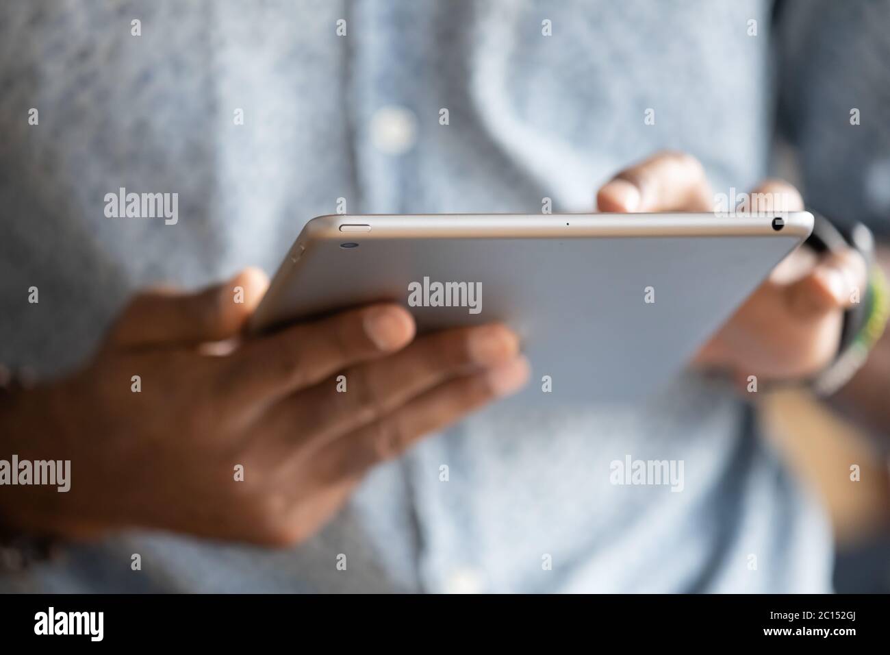 Close up hands of African man holding digital tablet device Stock Photo