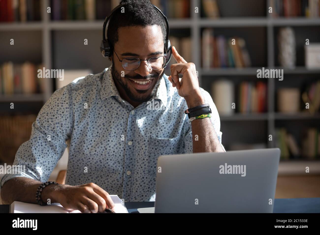 African man wear headset watching webinar video course Stock Photo