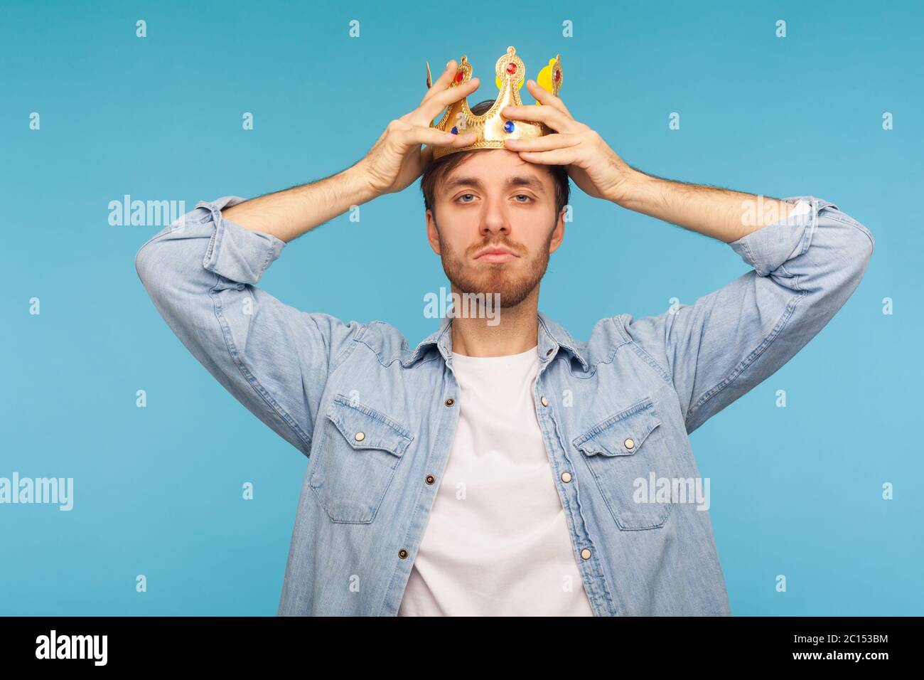 I'm ceo! Portrait of worker man wearing golden crown, imagining promotion at work to position of top manager or boss, looking with arrogance, privileg Stock Photo