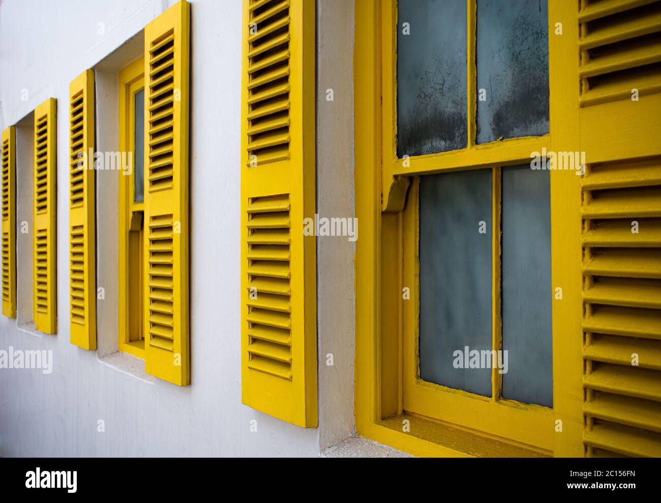 Windows with bright yellow shutters Stock Photo Alamy