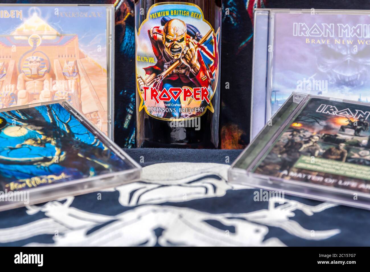 A Still Life of memorabilia of the Heavy Metal Band, Iron Maiden, with CD's, 'T' Shirt and a Bottle of Beer with their Trooper Logo on the front Stock Photo