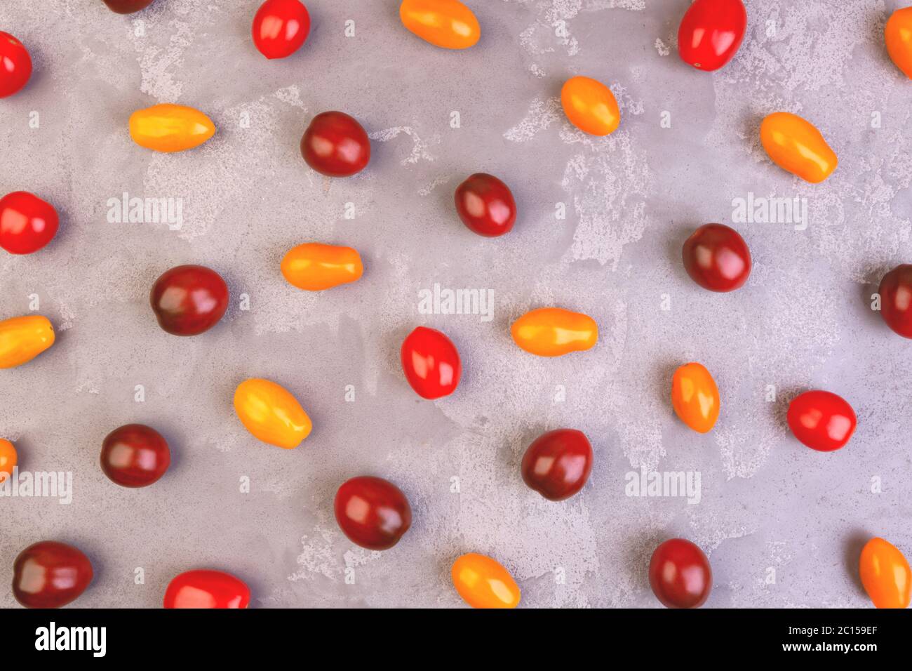Cherry tomatoes on gray marble background. Pattern. Stock Photo