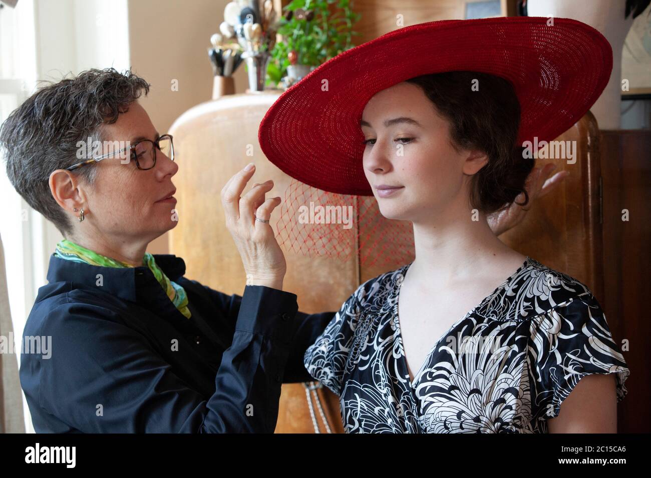 London, UK, 14 June 2020: Milliner Leanne Fredrick prepares one of her hats, modelled by her daughter Eliana, for the social media fundraiser 'Royal Ascot at Home' which will run from 16th to 20th June. As the horse-racing and social event has been cancelled due to coronavirus social distancing safety measures, people are encouraged to post photos of their hats and outfits with the hastag #StyledWithThanks and make a donation to Ascot's chosen Covid-19 charities. Anna Watson/Alamy Live News. Stock Photo