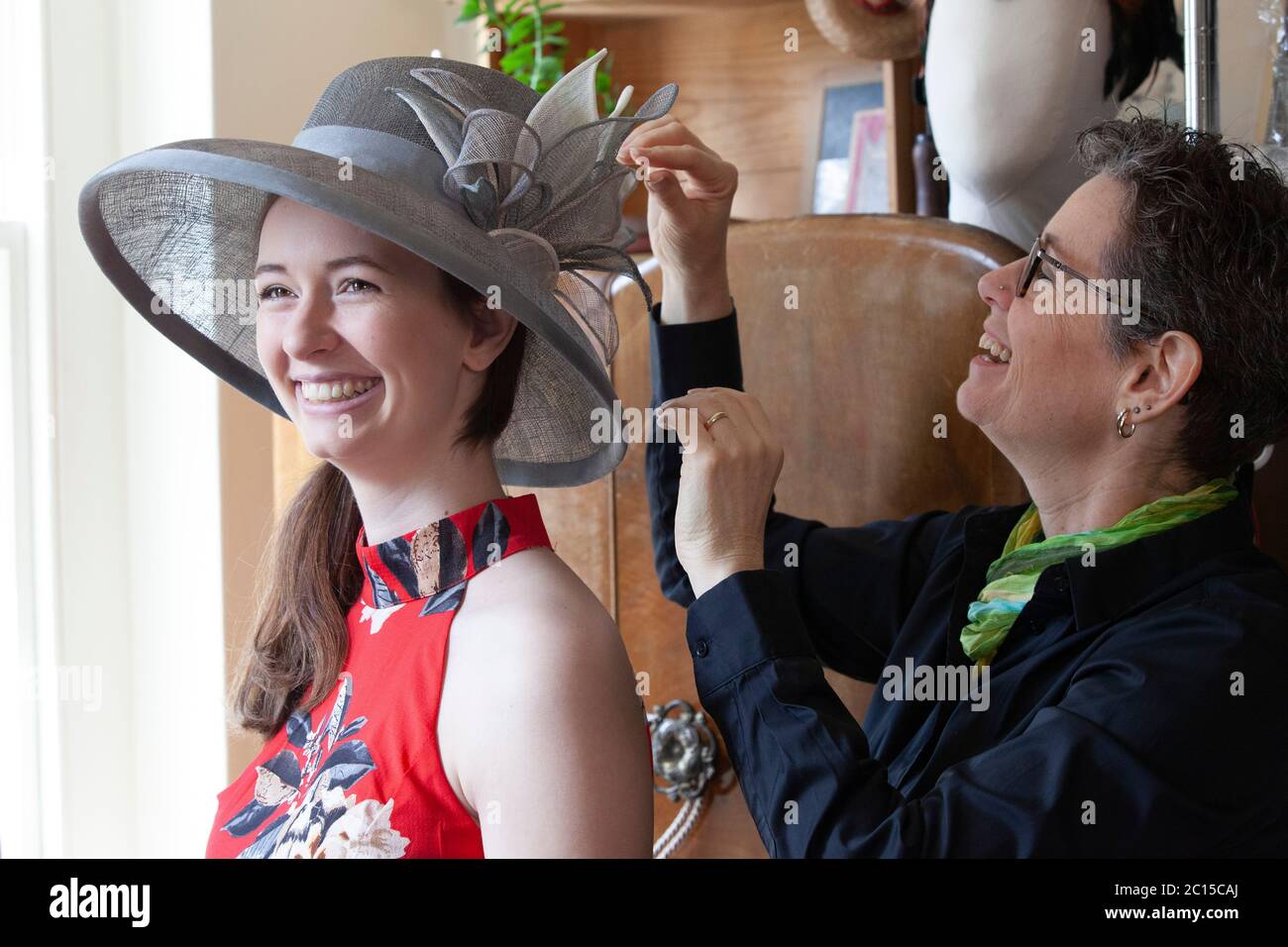 London, UK, 14 June 2020: Milliner Leanne Fredrick prepares one of her hats,  modelled by her daughter Emeline, for the social media fundraiser 'Royal  Ascot at Home' which will run from 16th