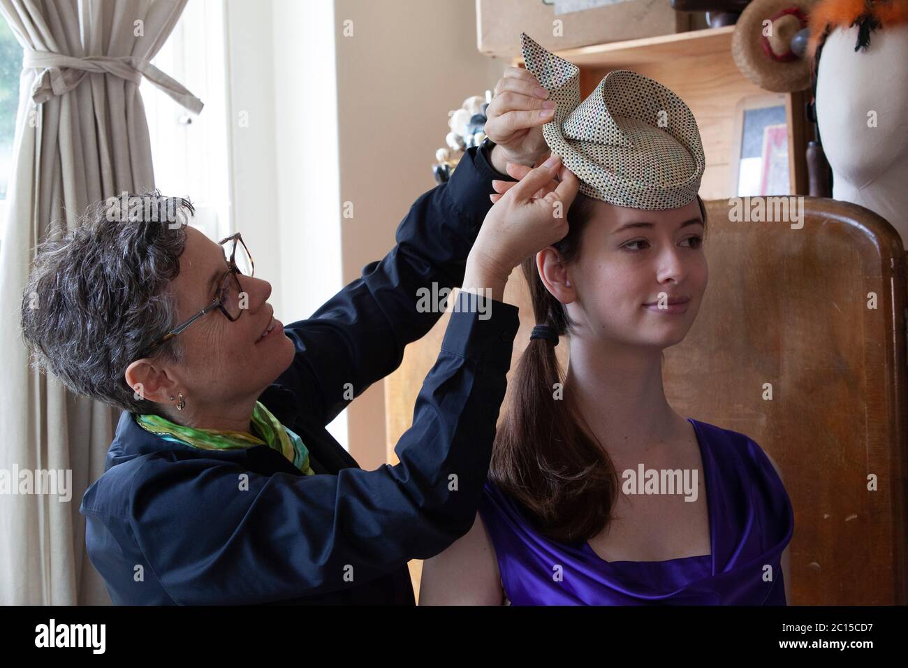 London, UK, 14 June 2020: Milliner Leanne Fredrick prepares one of her hats, modelled by her daughter Emeline, for the social media fundraiser 'Royal Ascot at Home' which will run from 16th to 20th June. As the horse-racing and social event has been cancelled due to coronavirus social distancing safety measures, people are encouraged to post photos of their hats and outfits with the hastag #StyledWithThanks and make a donation to Ascot's chosen Covid-19 charities. Anna Watson/Alamy Live News. Stock Photo