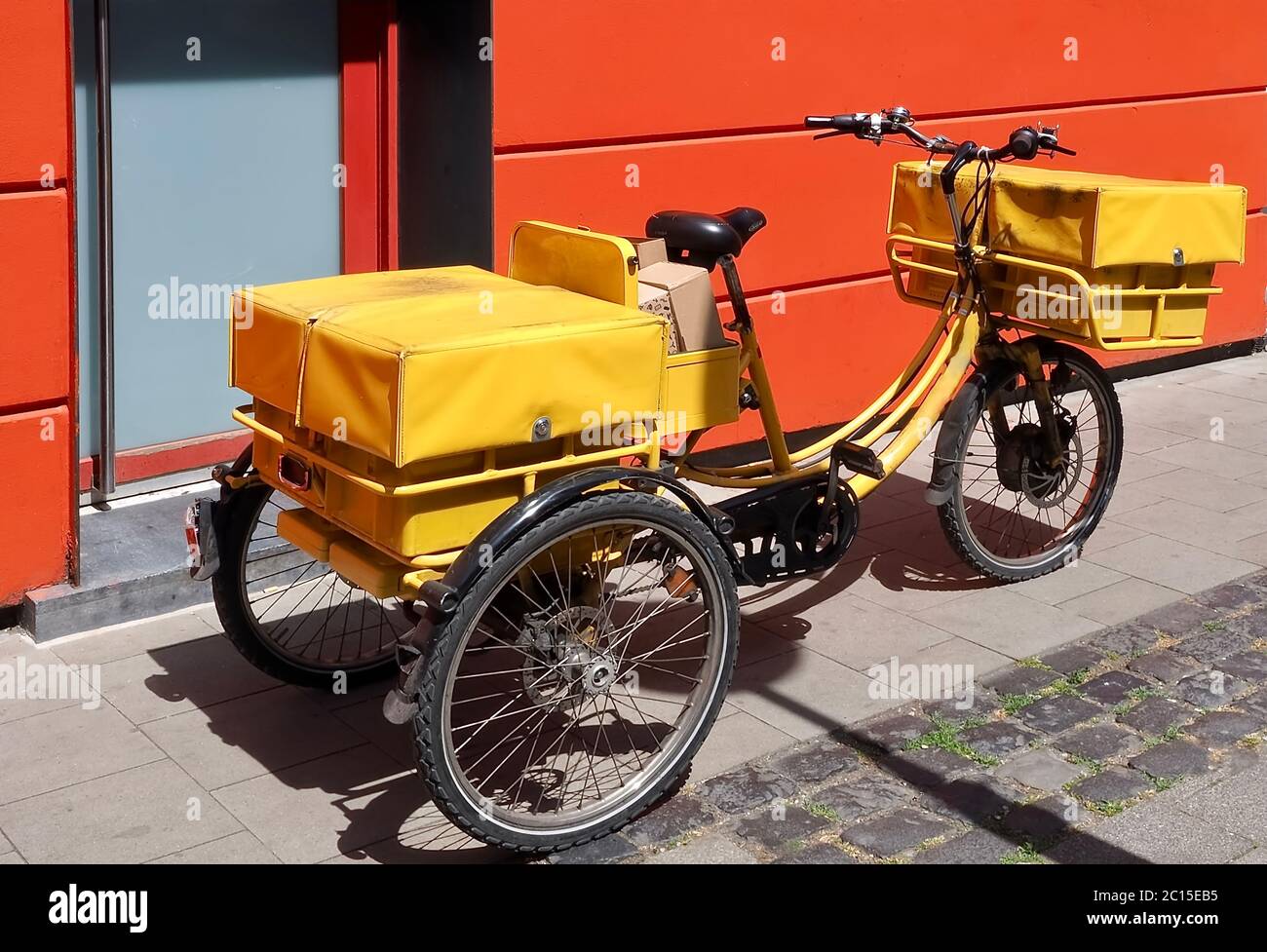 Yellow Bicycle of a post man packed with letters and parcels Stock Photo