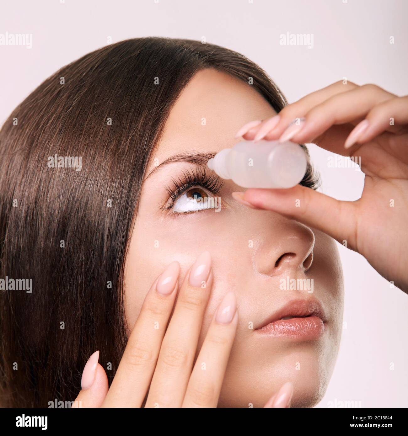 Young girl using eye drops. Glaucoma recovery Stock Photo