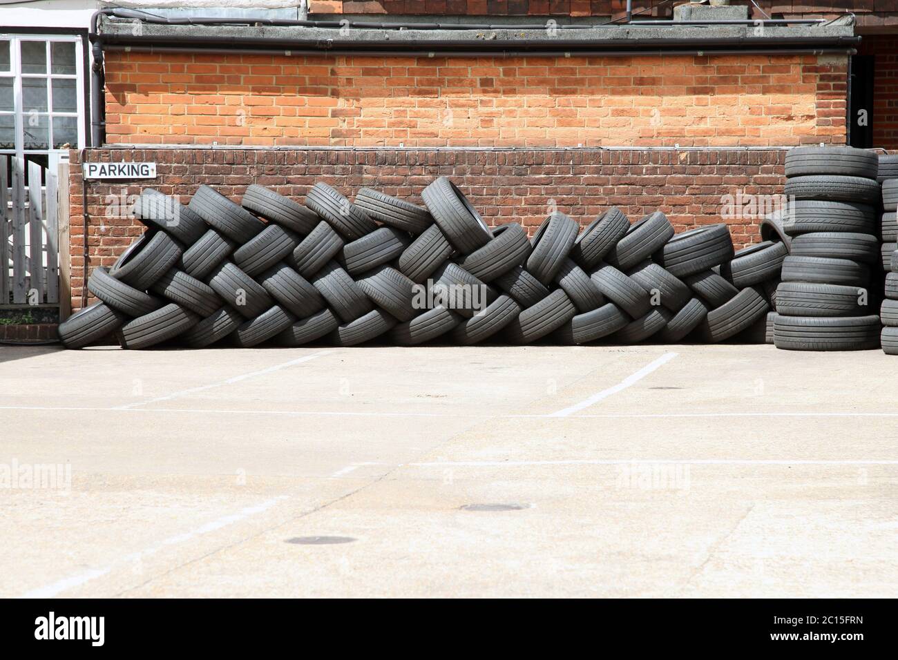 A pile of tyres sit on car park of tyre fitting centre Stock Photo