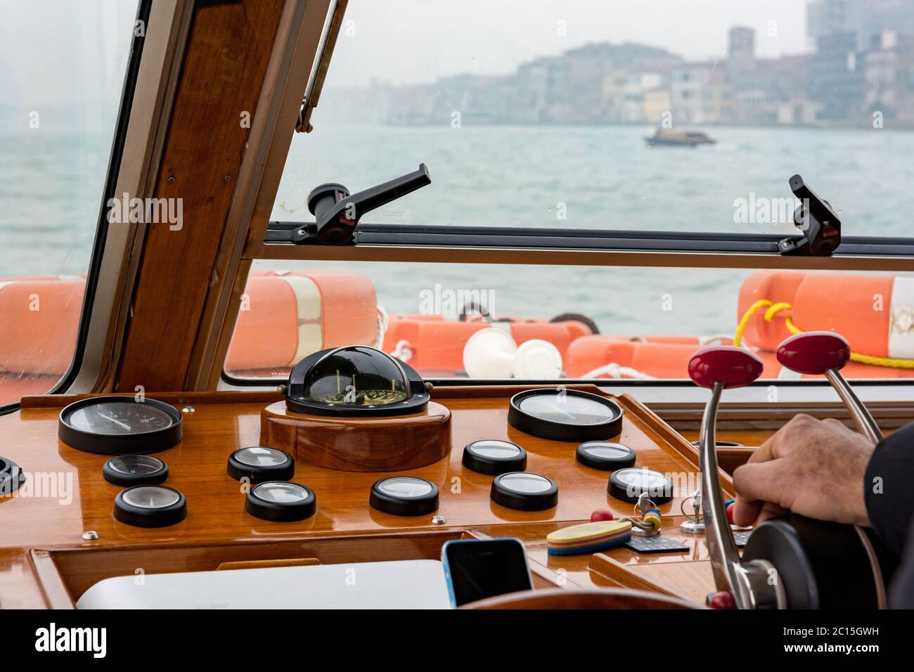 Captain driving an old wooden boat - rear view Stock Photo - Alamy