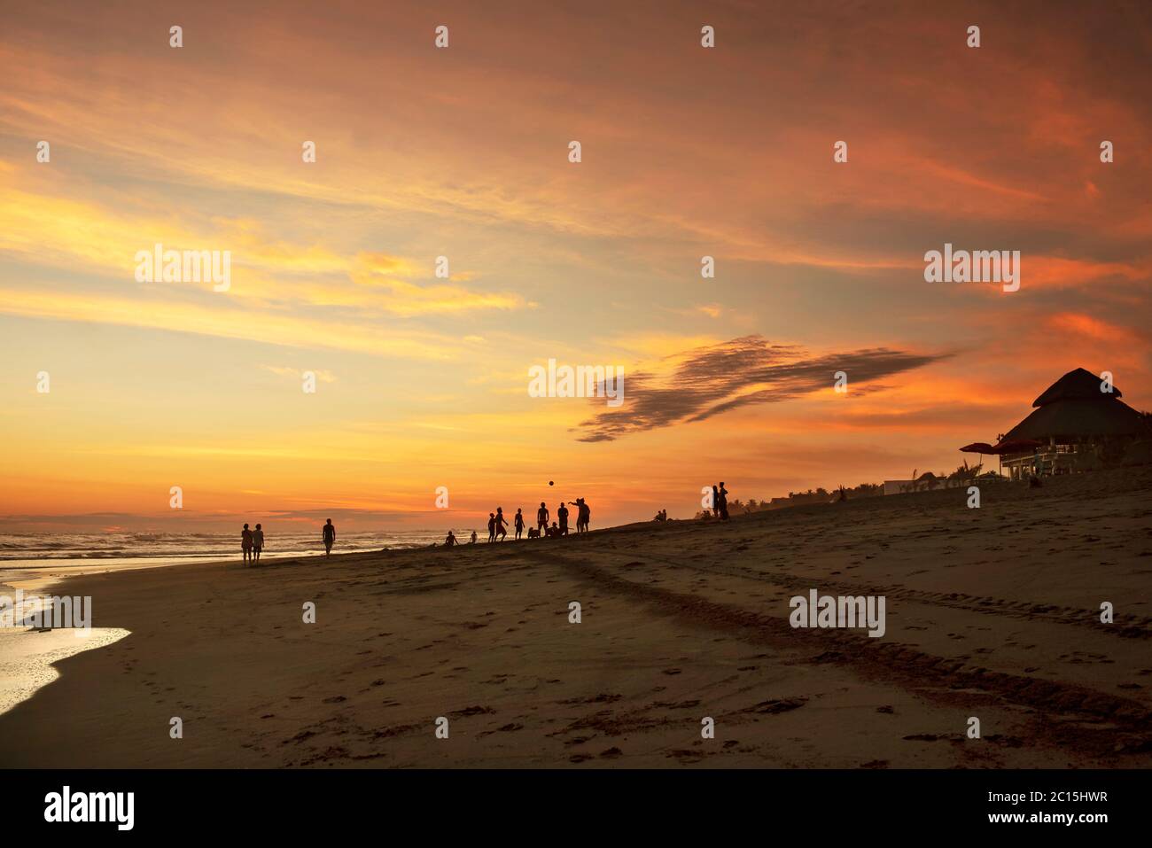 Silhouette of people playing on the beach after sunset. The black sand coast of El Paredón, Guatemala Stock Photo