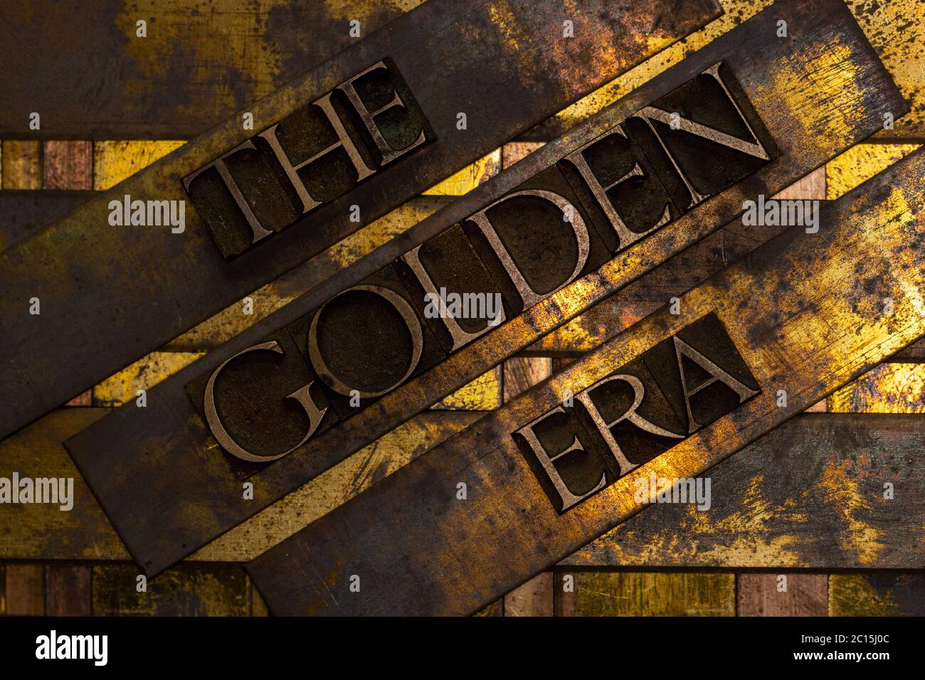 The Golden Era text formed with real authentic typeset letters on vintage textured silver grunge copper and gold background Stock Photo