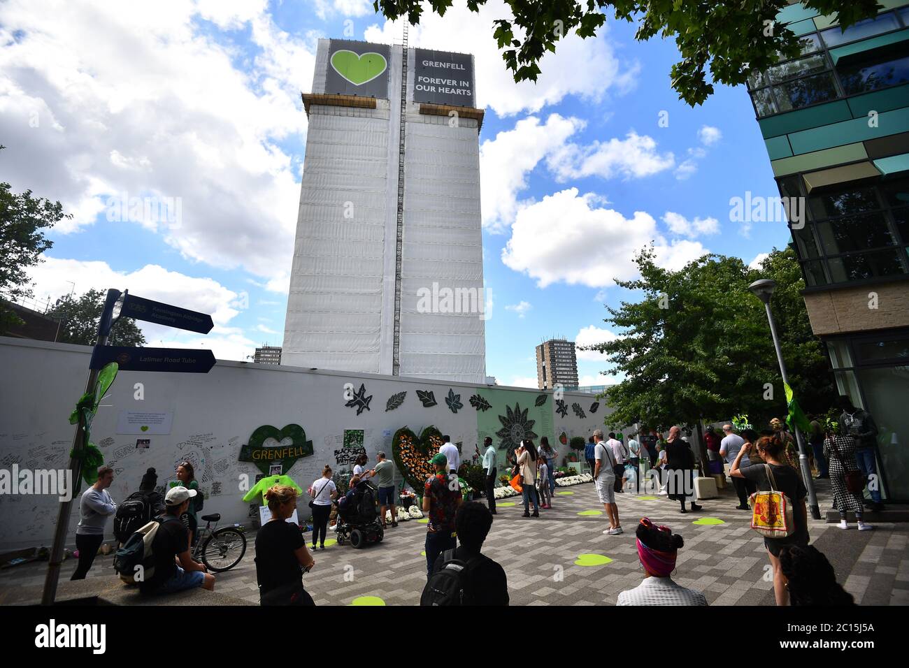 People at the Grenfell Memorial Community Mosaic at the base of the tower block in London on the third anniversary of the Grenfell Tower fire which claimed 72 lives on June 14 2017. Stock Photo