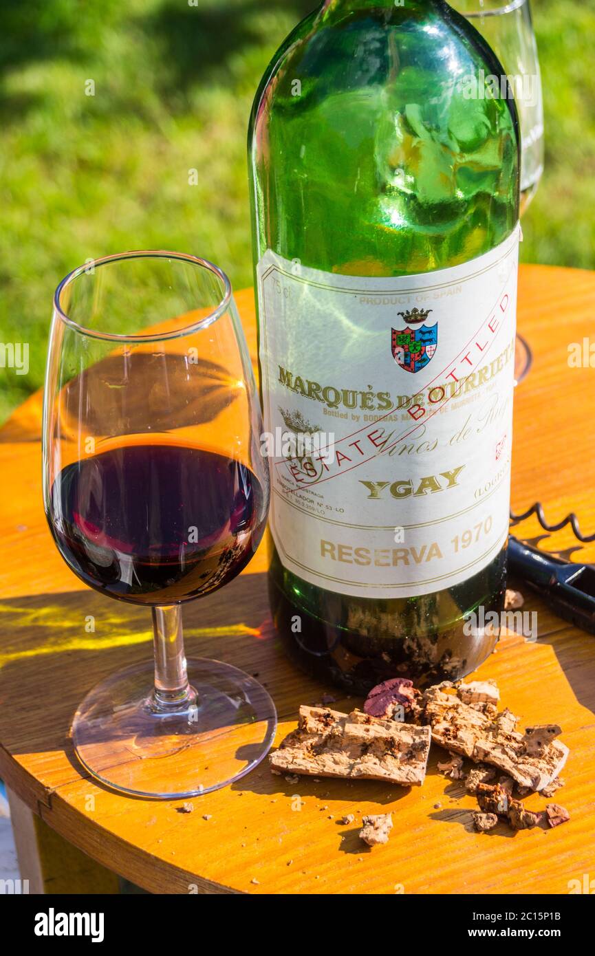 A bottle and glass of 1970 Marquès de Murrieta Ygay Rioja Spanish red wine on an outdoor table at a private wine tasting on a sunny afternoon Stock Photo