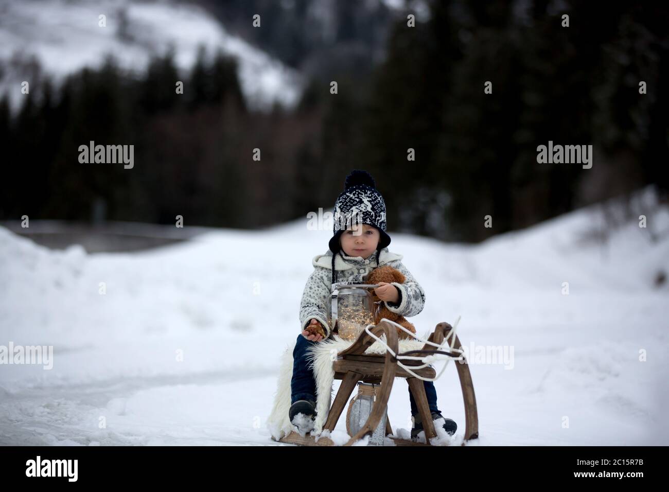 Cute boy playing with teddy bear in the snow, winter time. Little ...