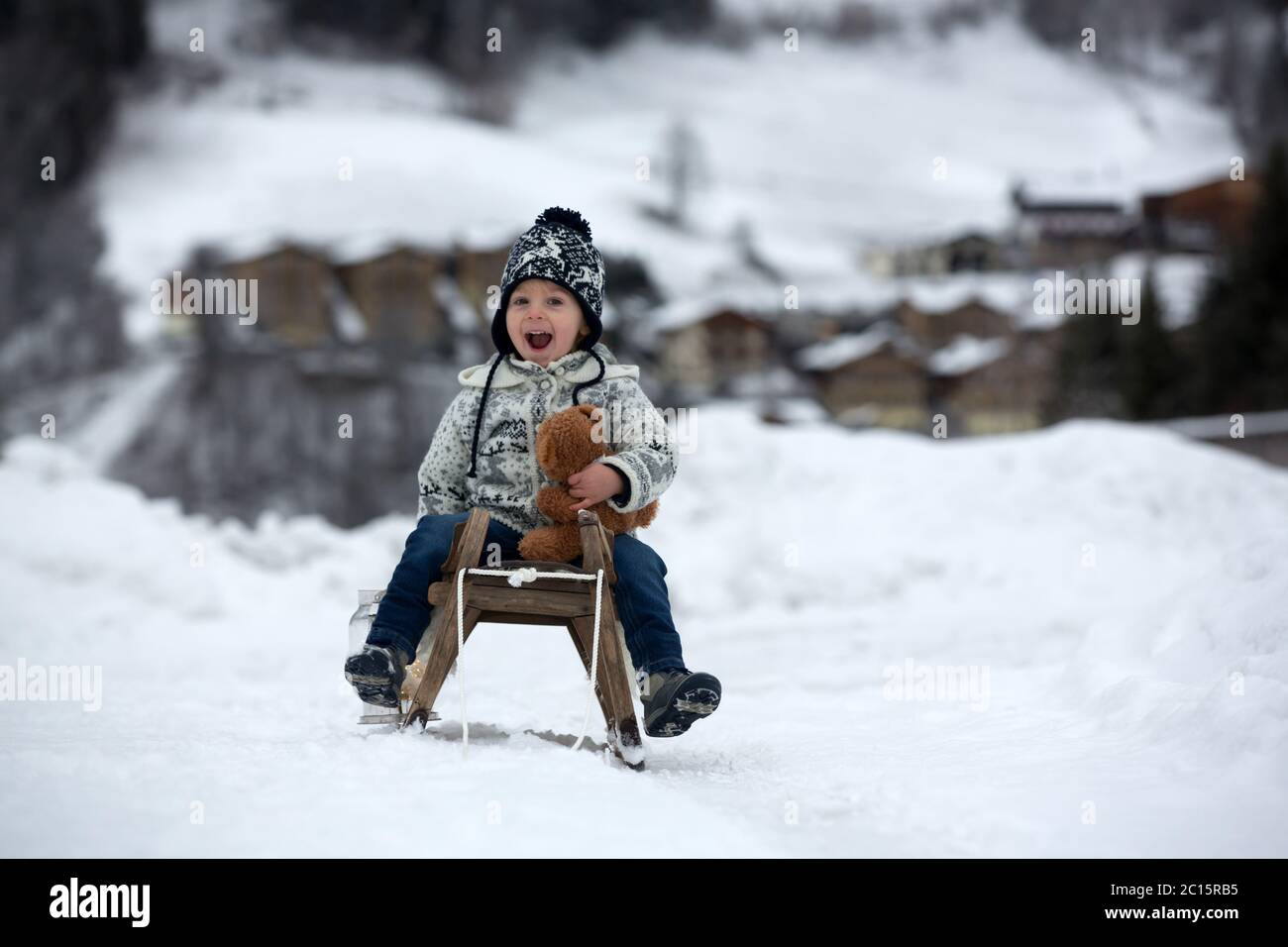 Cute boy playing with teddy bear in the snow, winter time. Little ...