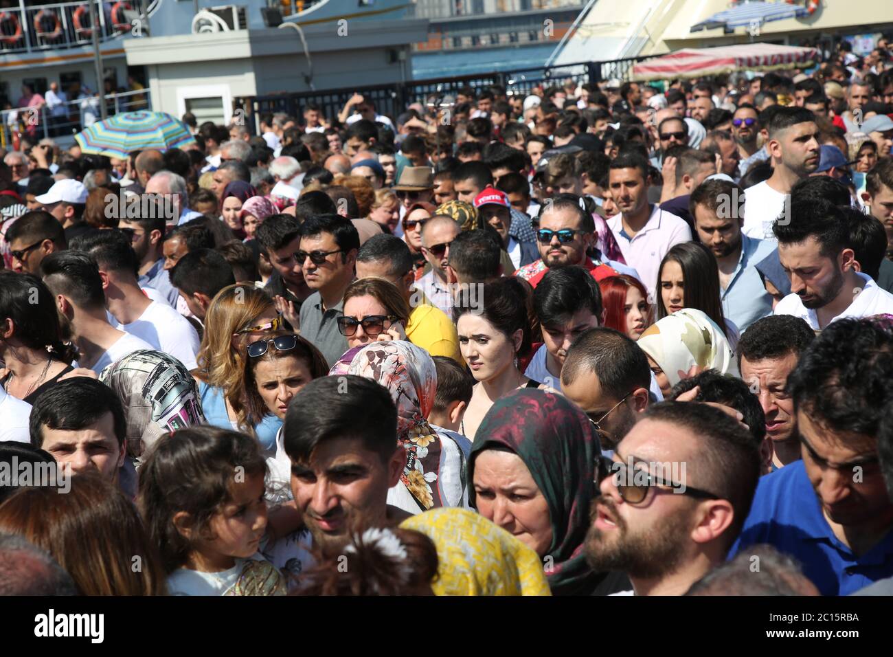 EMINONU, ISTANBUL, TURKEY; JUNE 26, 2018. People crowd walking through street. Crowds beside the Bosphorus, with mosque in background, in Istanbul. Stock Photo