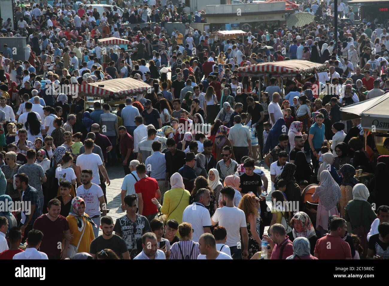 EMINONU, ISTANBUL, TURKEY; JUNE 26, 2018. People crowd walking through street. Crowds beside the Bosphorus, with mosque in background, in Istanbul. Stock Photo
