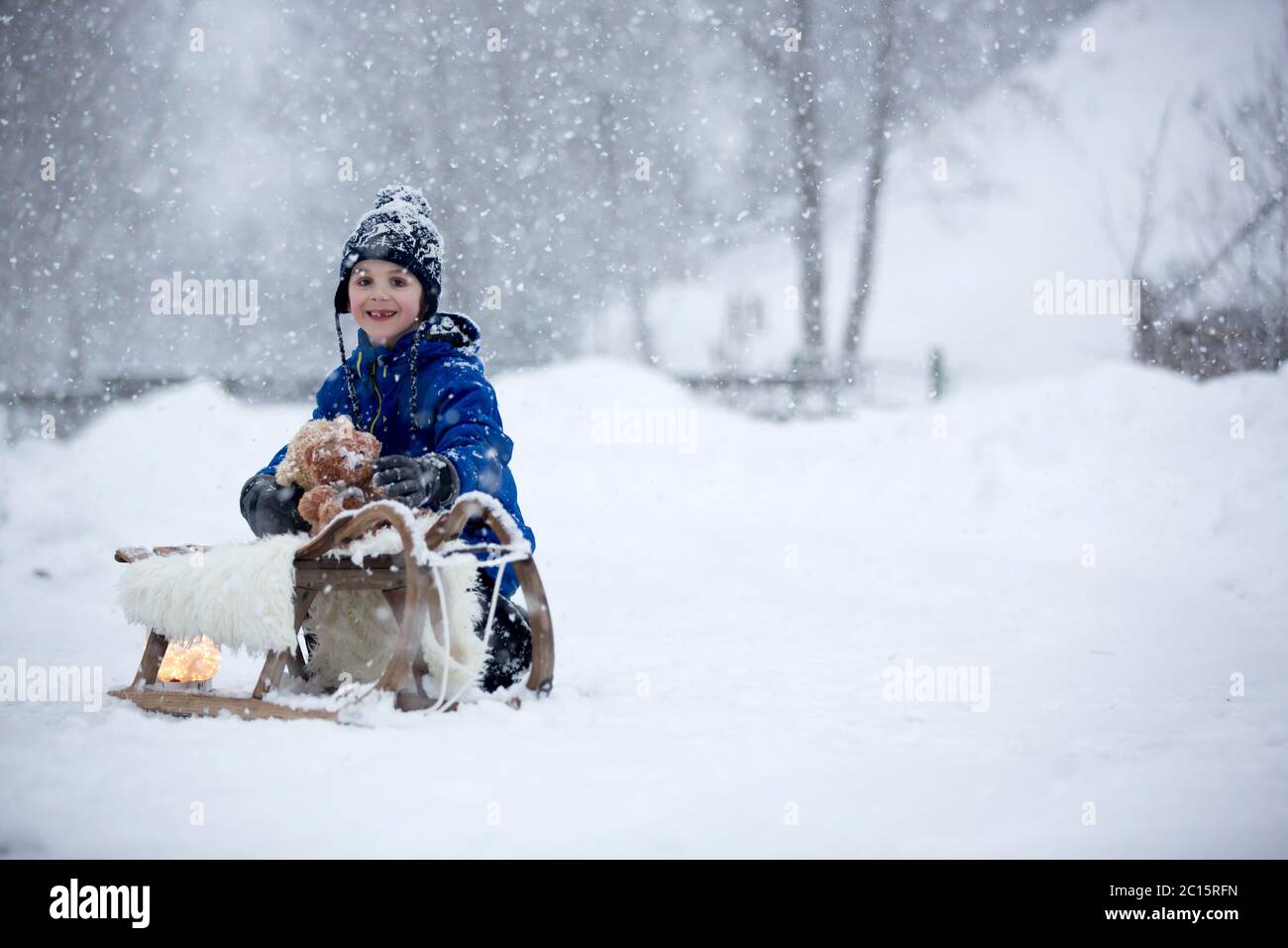 Cute boy playing with teddy bear in the snow, winter time. Little ...