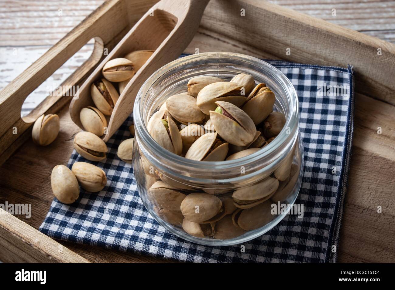 Pistachio nuts inside bowl on rustic table. Pistachios are healthy nuts packed with fiber and antioxidants. Natural source of vitamins, often found in Stock Photo