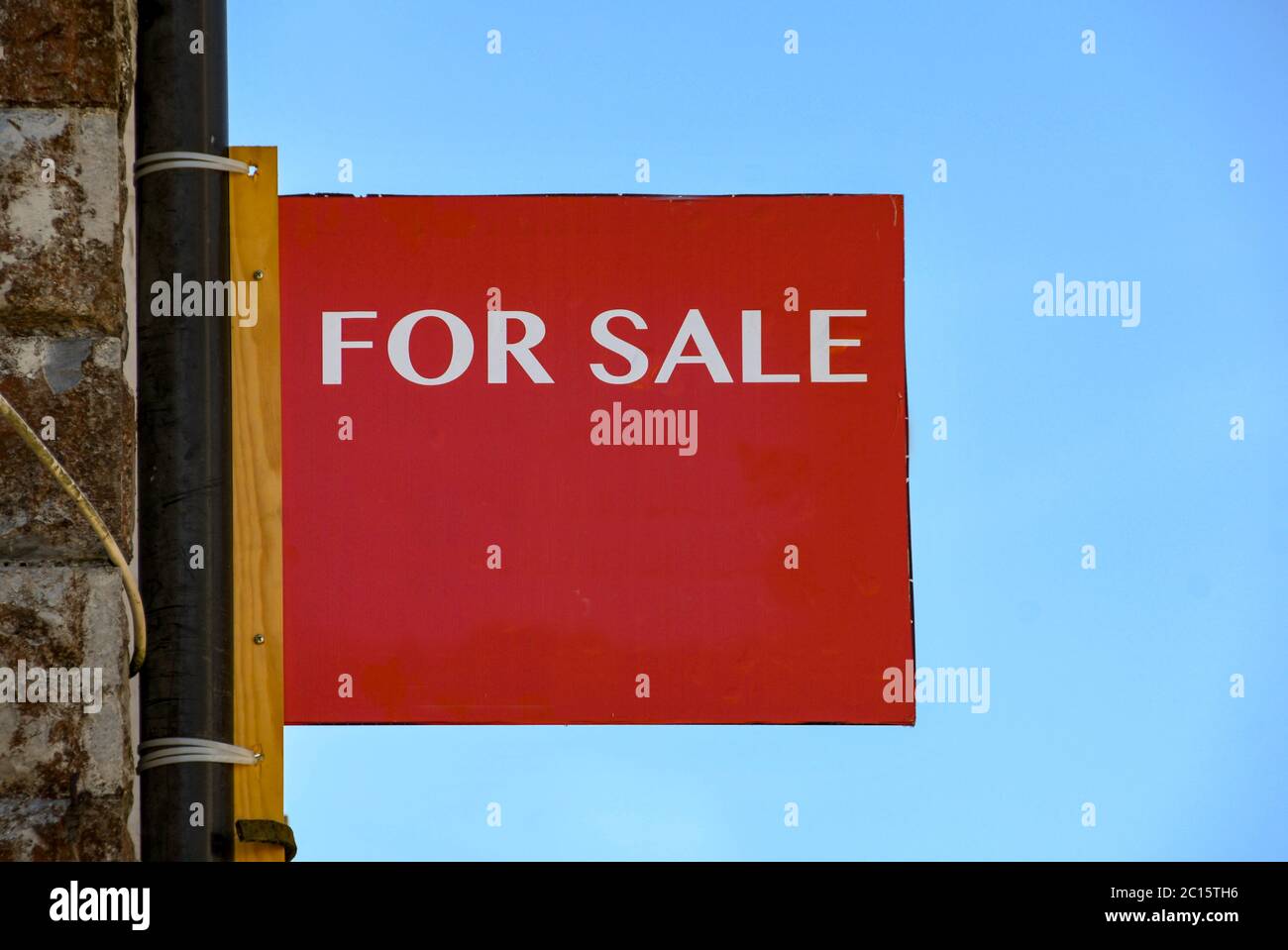 "For sale" sign attached to the wall of a commercial property Stock