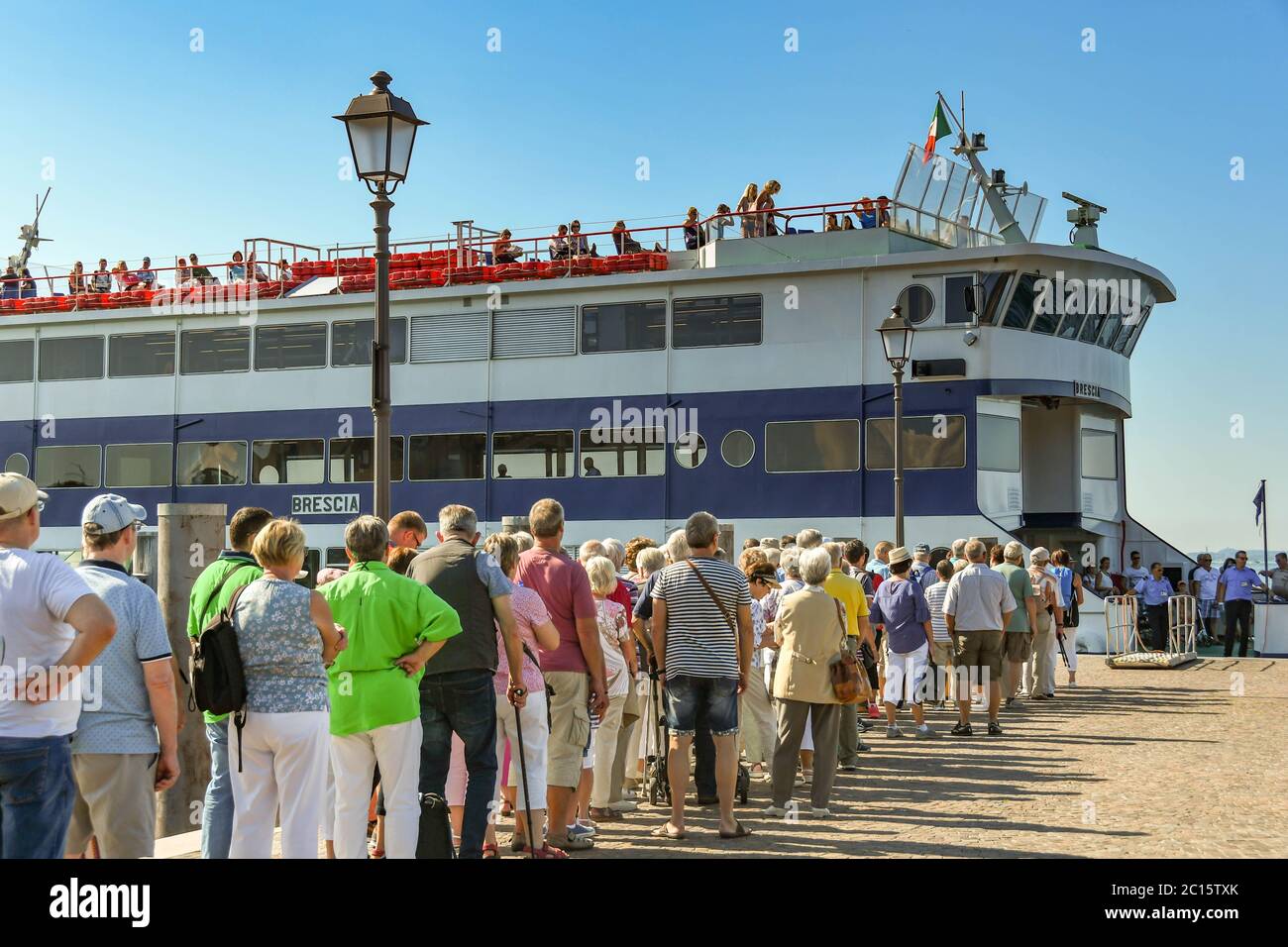 GARDA, ITALY - SEPTEMBER 2018: long queue of passengers waiting to board a large passenger ferry at Garda on Lake Garda. Stock Photo