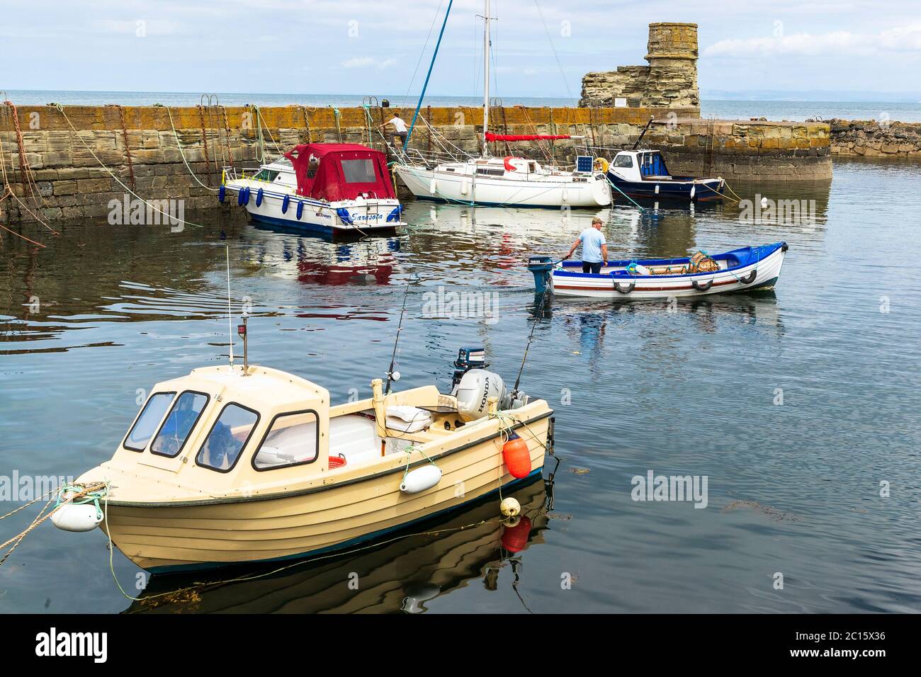 Small fishing boat leaving Dunure harbour, Ayrshire, Scotland, UK Stock Photo