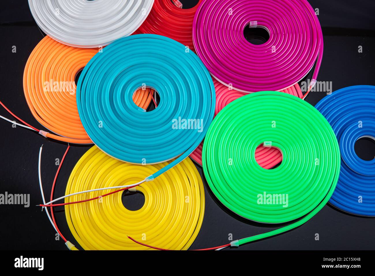 Neon flexible strip light. Flexible led tape neon flex in different colors on black background. Stock Photo