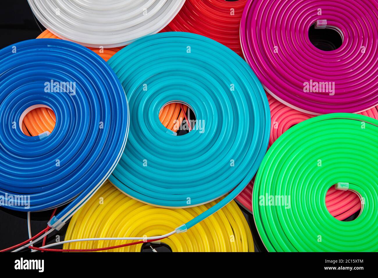 Neon flexible strip light. Flexible led tape neon flex in different colors on black background. Stock Photo