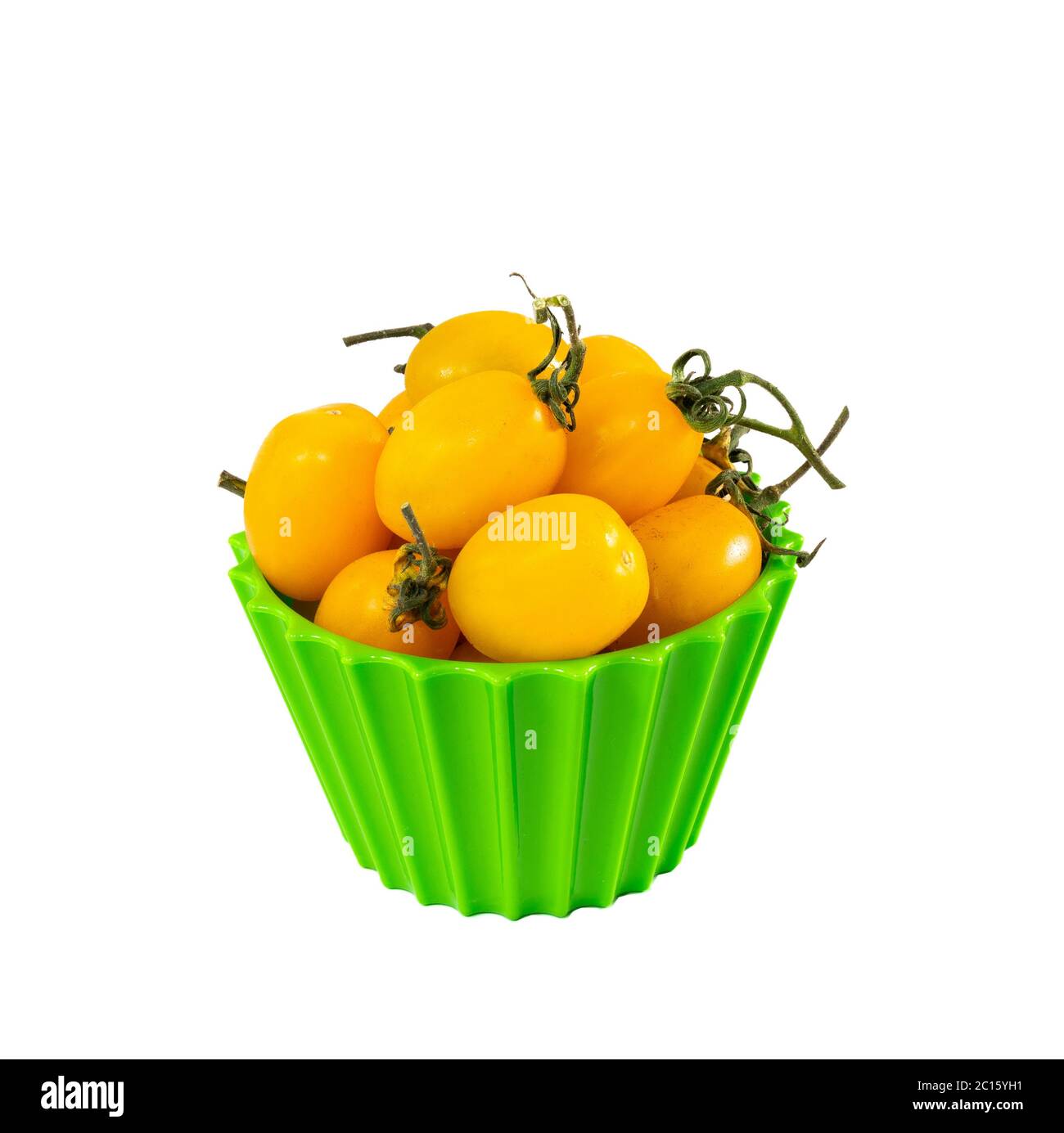 Sweet little yellow cherry tomatoes on green bowl on grey background Stock Photo