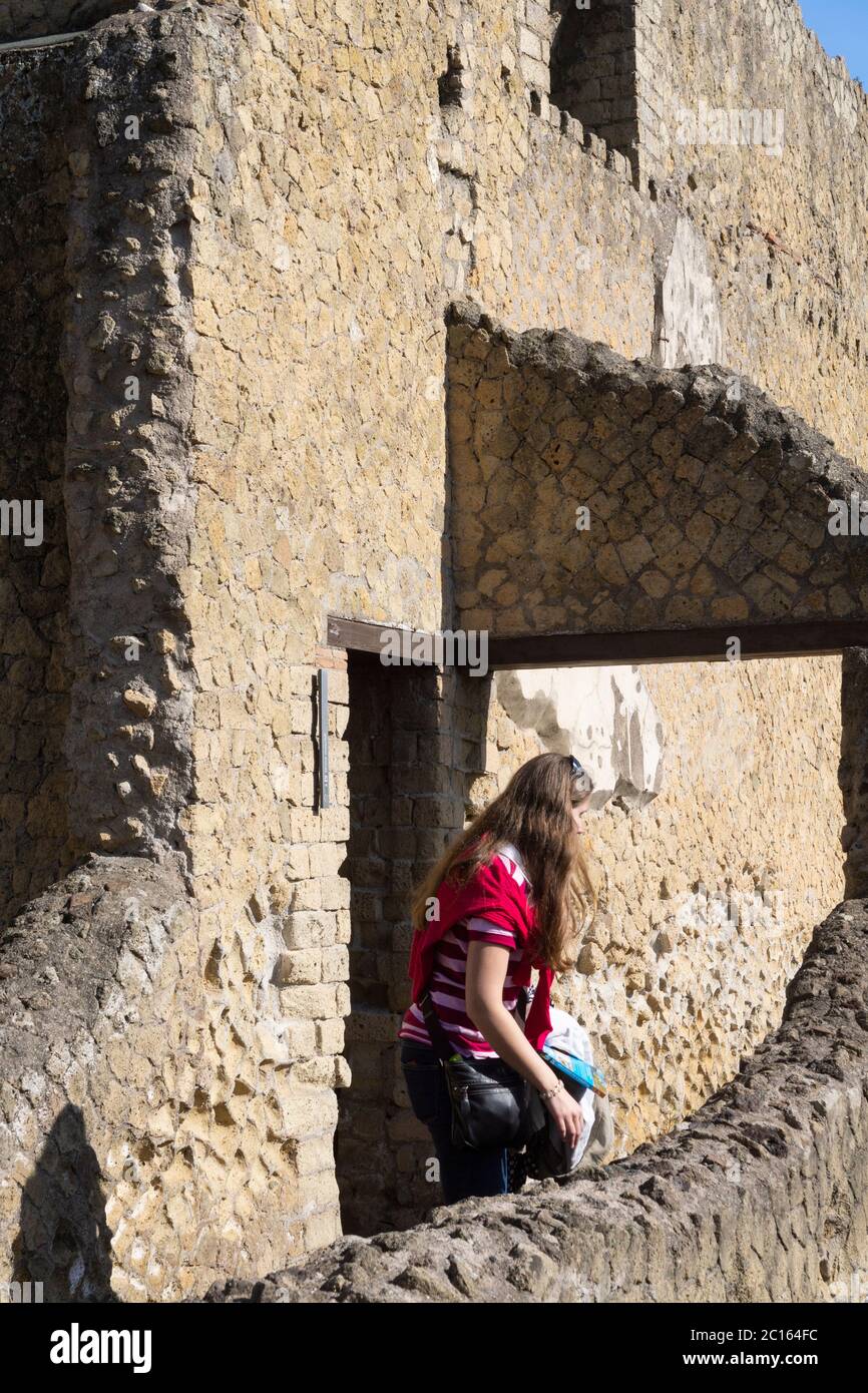 A woman tourist walking through the entrance to the Terme Maschili / Centrali (Male area of the Central Baths), ancient Roman city of Herculaneum Stock Photo