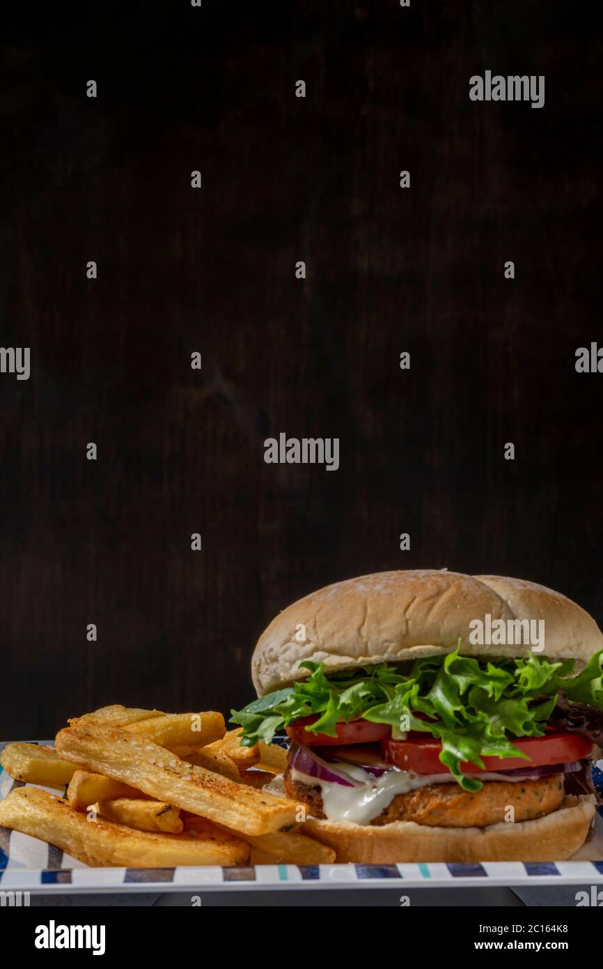 Salmonburger with home cooked oven baked fries Stock Photo Alamy