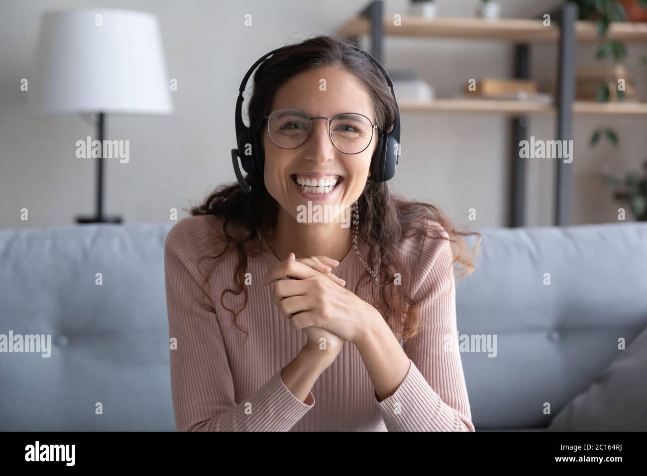 Head shot portrait smiling woman wearing headset and glasses Stock