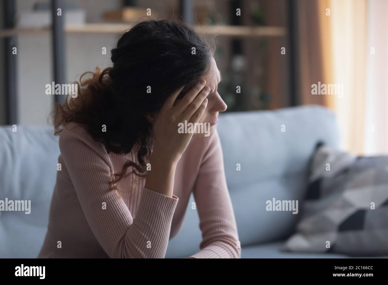 Unhappy depressed woman touching forehead, thinking about problems Stock Photo