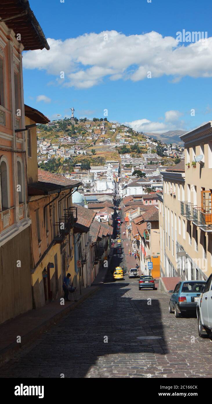 Quito, Pichincha / Ecuador - August 25 2018: People walking on Garcia Moreno street in the historic center of Quito with the virgin of El Panecillo in Stock Photo