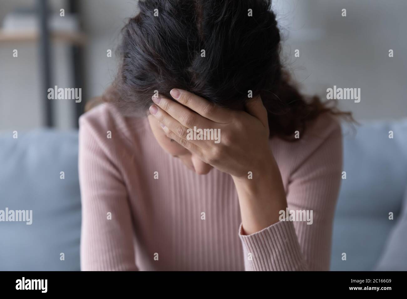 Close up unhappy depressed young woman touching forehead Stock Photo