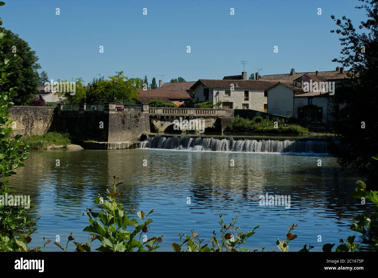 The old bridge and weir at Allemans du Dropt. Stock Photo