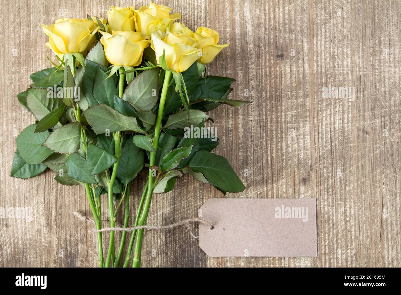 Bunch of yellow roses with blank tag Stock Photo