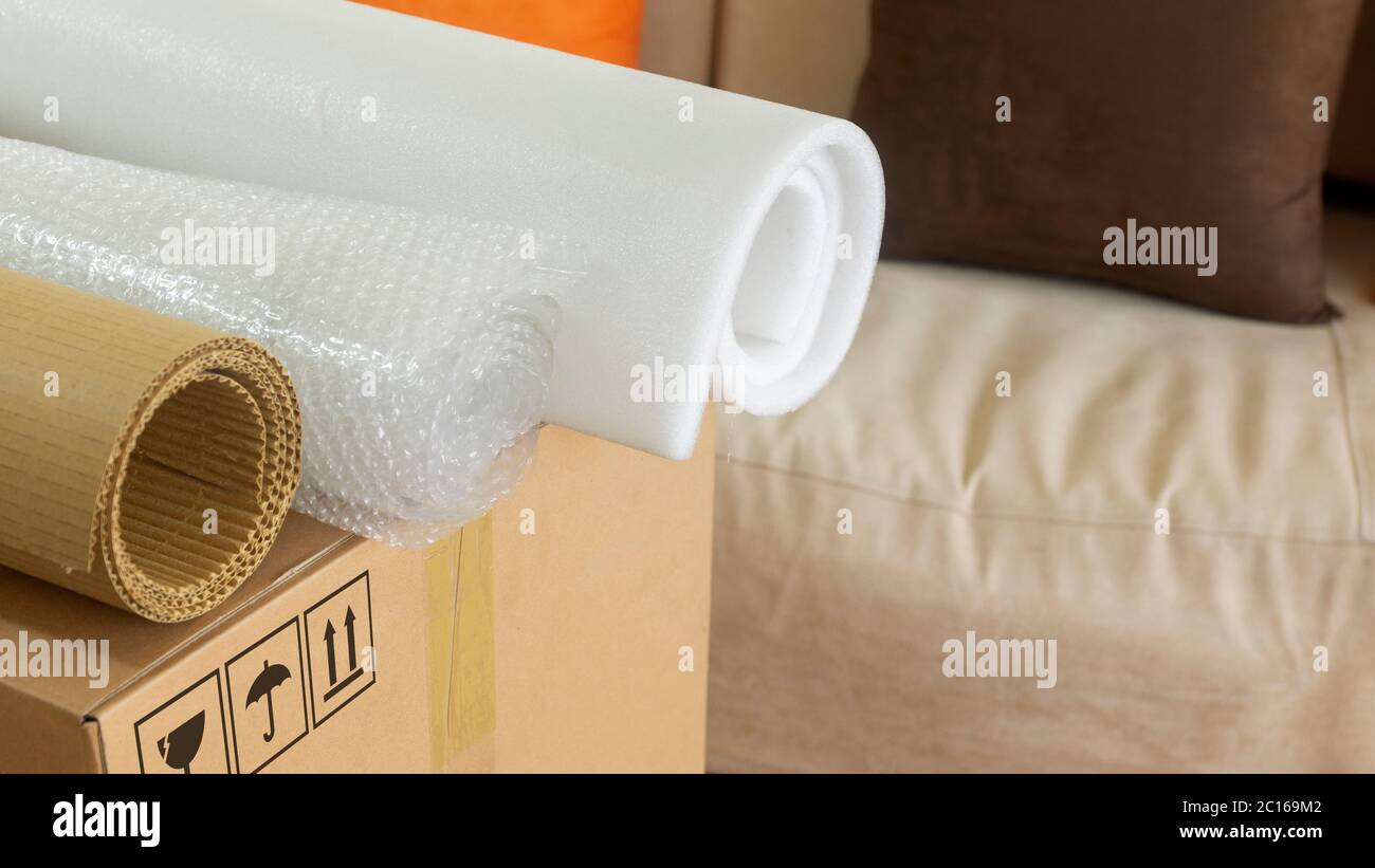 Approach to three rolls of cardboard, foam and bubble wrap used to pack