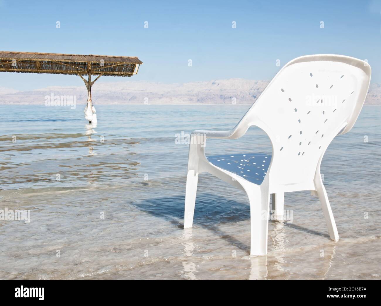 plastic easy chair in the shallow waters of the world famous Dead Sea, Israel. Stock Photo
