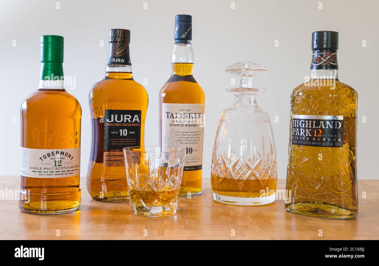 Scotch malt whisky brand bottles, crystal decanter and whisky glass: Tobermory whisky, Jura whisky, Taiisker & Highland Park Viking Honour whisky Stock Photo
